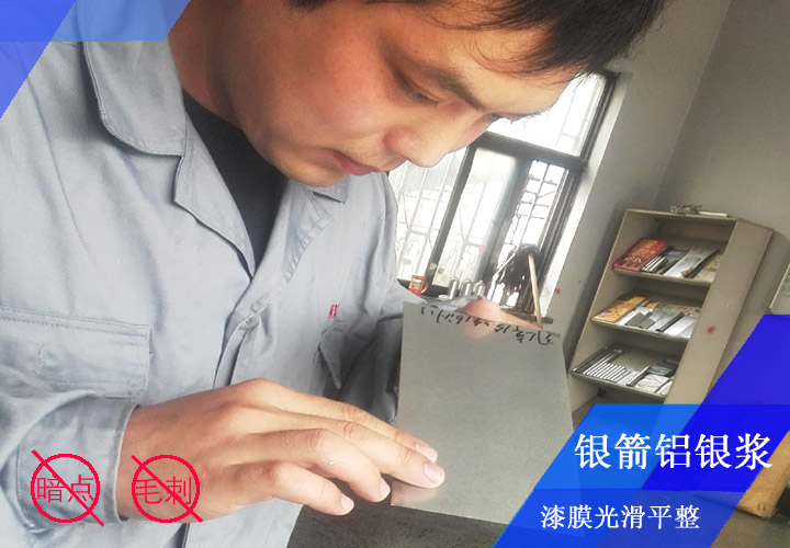 銀箭鋁銀漿工程師李工正在對(duì)發(fā)動(dòng)機(jī)殼烤漆漆膜看板檢測(cè)，確保漆膜光滑平整無暗點(diǎn)、無毛刺